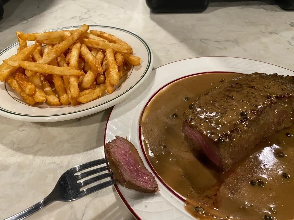 A plate of steak and fries on the table.